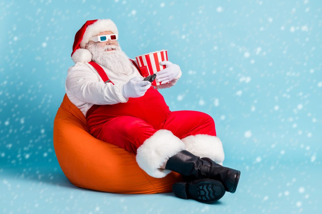 Santa eating popcorn and watching Christmas movies